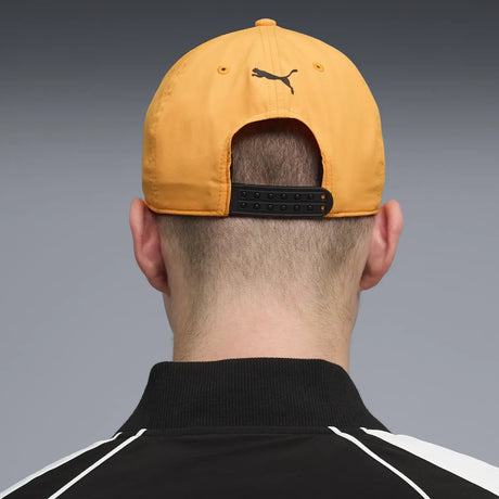 Person wearing orange McLaren cap back view